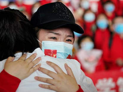 Una trabajadora de un equipo médico se despide en el aeropuerto de Wuhan después de que China haya levantado las restricciones sobre la capital de la provincia de Hubei, en el centro del país.