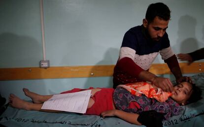 Un hombre atiende en un hospital a una niña herida el sábado en el bombardeo israelí sobre Gaza.