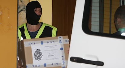 Un policía saca documentos del Ayuntamiento de Estepona.