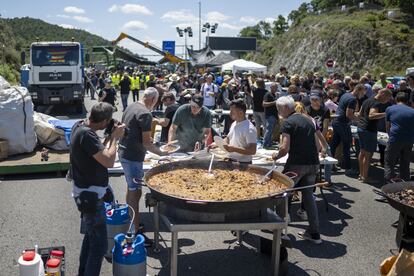 Varias personas preparan una paella en la AP-7, a la altura de La Junquera (Girona), durante el parón de tráfico.