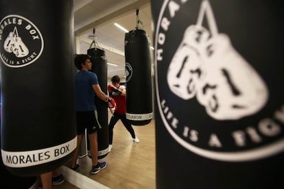 Dos jóvenes se turnan en el golpeo del saco.