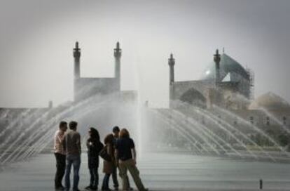 Un grupo de turistas ante las fuentes de la plaza Naghshe Jahan, en Isfahan (Irán).