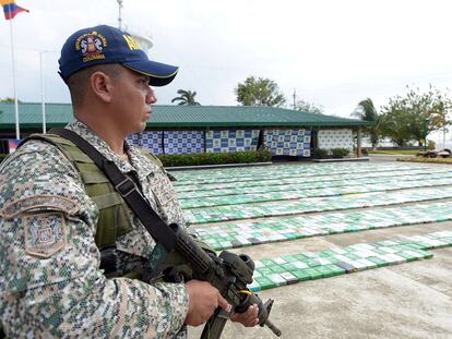 A member of the Colombian military stands next to a cocaine haul in the city of Turbo.