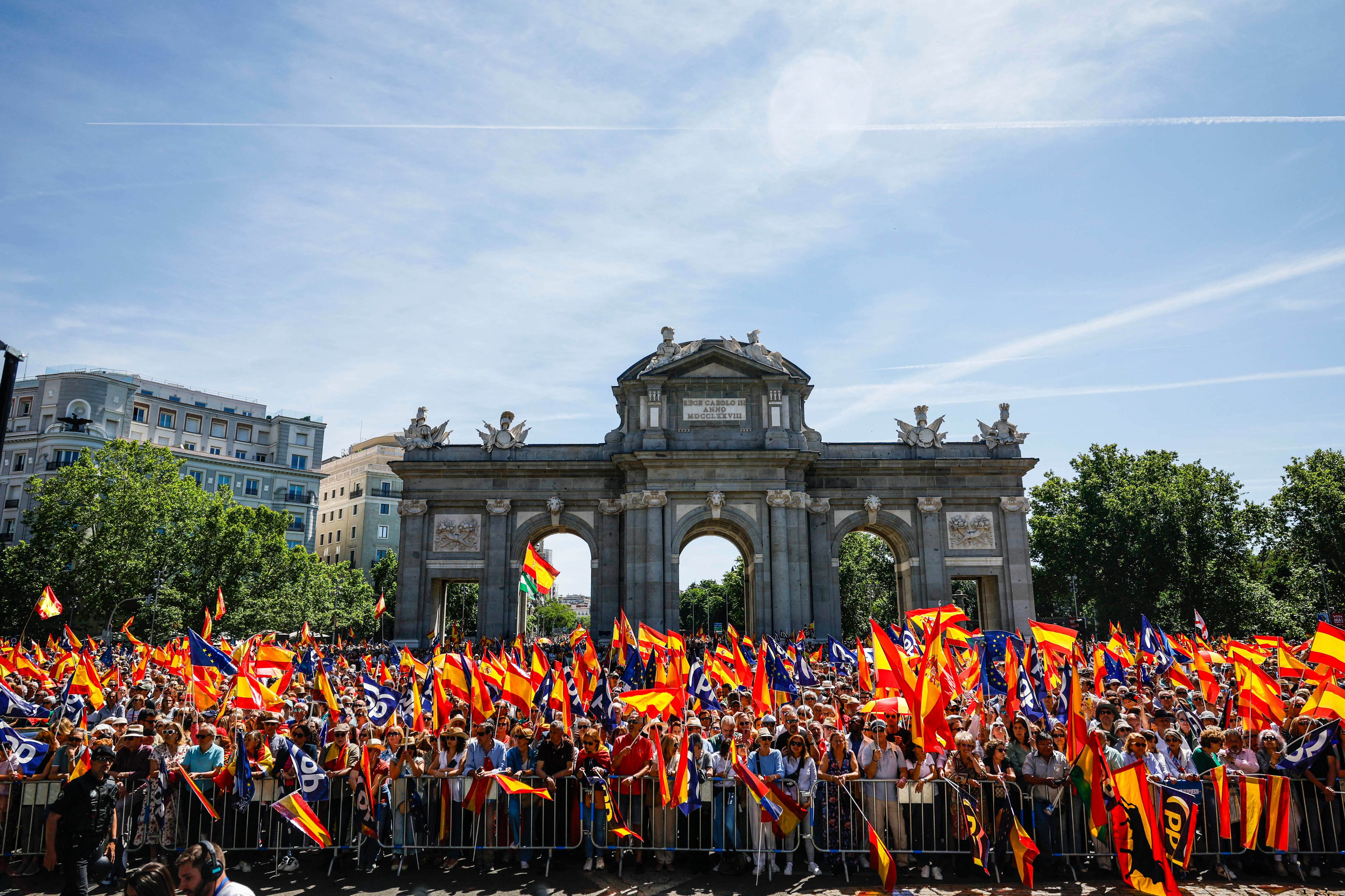 Manifestantes portan banderas de España, Europa y Partido Popular en la plaza de la Independencia de Madrid, este domingo.