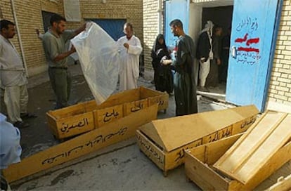 Un grupo de iraquíes prepara los ataúdes para sus familiares en la morgue de Bagdad.
