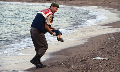 Un policía traslada el cadáver del niño Aylan Kurdi, muerto en playas turcas este otoño en la huída de su familia hacia Europa