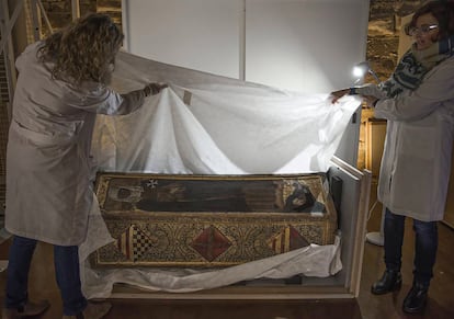 Dos conservadoras desembalan la caja mortuoria de Isabel de Aragón en el monasterio de Sijena tras su llegada desde el Museo de Lleida.