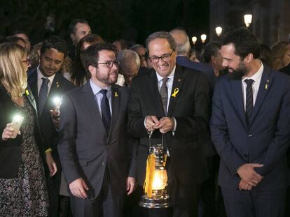 Torra (centro) sostiene la 'Flama del Canigó' junto a Pere Aragonés (izquierda) y Roger Torrent.