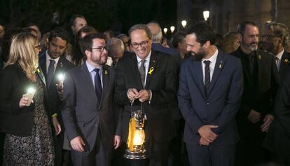 Torra (centro) sostiene la 'Flama del Canigó' junto a Pere Aragonés (izquierda) y Roger Torrent.