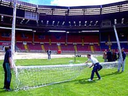 Los operarios cargan con una de las porterías del estadio de Wembley, ayer.