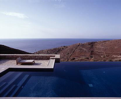Esta vivienda en las islas Cícladas, firmada por el arquitecto libanés Tala Mikdashi y la proyectista griega Maria Doxa, mira hacia el mar Egeo. Junto a la piscina, la hamaca reclinable de Gijs es un diseño de Piet Boon construido en iroko macizo
