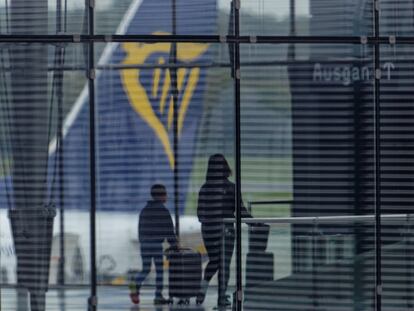 07 October 2023, North Rhine-Westphalia, Cologne: Travelers walk through Terminal 2 of Cologne Bonn Airport with suitcases. In the background, the tail unit of an aircraft of the airline Ryanair can be seen. Photo: Henning Kaiser/dpa (Photo by Henning Kaiser/picture alliance via Getty Images)