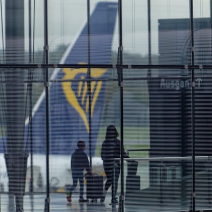 07 October 2023, North Rhine-Westphalia, Cologne: Travelers walk through Terminal 2 of Cologne Bonn Airport with suitcases. In the background, the tail unit of an aircraft of the airline Ryanair can be seen. Photo: Henning Kaiser/dpa (Photo by Henning Kaiser/picture alliance via Getty Images)