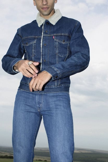 Este otoño, el ‘denim’ vuelve al origen: ceñido, en tono índigo ligeramente gastado y sin miedo al ‘total look’. Tanto el pantalón vaquero clásico como la chaqueta ‘trucker’ con cuello de borrego son Levi’s.