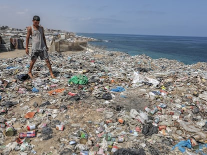 Un joven palestino pasa por una zona con basura que se acumula sin recoger en la costa de Deir al-Balah, en la franja de Gaza.