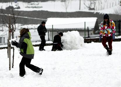 Varios niños juegan con la nieve hoy en la localidad guipuzcoana de Berastegi.