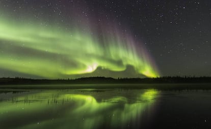 Aurora boreal reflejada en el lago Prosperous, al norte de Yellowknife, capital de los Territorios del Noroeste (Canadá).