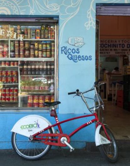 Una bicicleta de la red pública Ecobici, en México D.F., ante una tienda de alimentación.