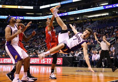 El jugador de los Suns Goran Dragic cae después de ser empujado por el jugador de los Clippers Caron Butler (en el centro).