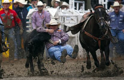 Un participante lucha con un toro en un  rodeo en Calgary, Alberta.