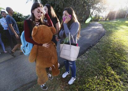 Estudiantes costernados por lo sucedido, esperan a que los recojan después del tiroteo en Marjory Stoneman Douglas High School en Parkland, Florida.