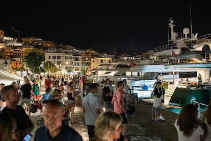 Tourists observing private yachts at the port of Ibiza in August.