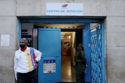 Un hombre hace guardia en la entrada de uno de los colegios electorales de Caracas. 