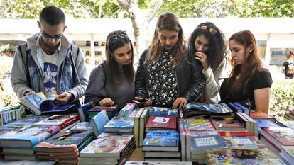 Jóvenes hojean algunos libros en uno de los stand de la Fira del Llibre de València. 