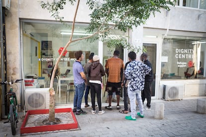 Un grupo de personas espera a que abra la oficina central del Centro Dignidad de la ONG Refugee Support. Uno de los lemas de la organización es la firme creencia de que “todo el mundo tiene derecho a la dignidad”. La ONG centra sus actividades en respetar a las personas como individuos, darles opciones, ofrecerles ayuda práctica con diversas actividades y crear las comunidades de apoyo que necesitan los emigrantes para ayudarles a reconstruir su vida en un sitio nuevo.