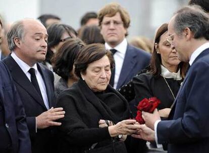 La viuda de Leopoldo Calvo-Sotelo recibe una rosa de su hijo Leopoldo.