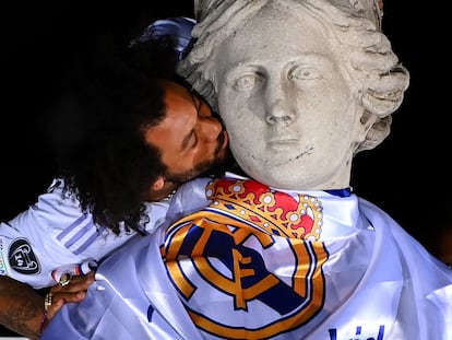 Real Madrid's Brazilian defender Marcelo kisses the statue of Greek goddess Cybele on May 29, 2022 at the Cibeles square in Madrid, a day after beating Liverpool in the UEFA Champions League final in Paris. - Real Madrid claimed a 14th European Cup as Vinicius Junior's goal saw them beat Liverpool 1-0 in the Champions League final at the Stade de France amid chaotic scenes yesterday. (Photo by GABRIEL BOUYS / AFP)
