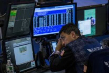 Un trader, enfundado en su elegante chaqueta, descansa la vista después del toque de campana en Wall Street.