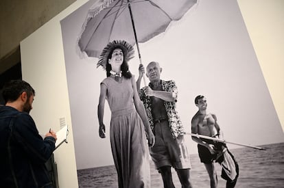 Un hombre observa la fotografía de Robert Capa de Picasso con Francoise Gilot y su sobrino Javier Vilato en 1948.