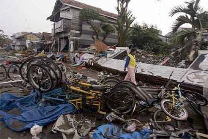 Una mujer camina entre los restos de casas destruidas por el maremoto en Pangandaran, en la isla de Java.