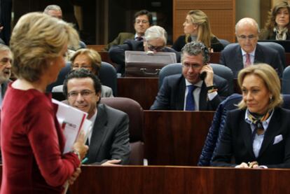 Esperanza Aguirre se dirige ayer a su escaño en la Asamblea de Madrid. En el centro, hablando por el móvil, Francisco Granados.