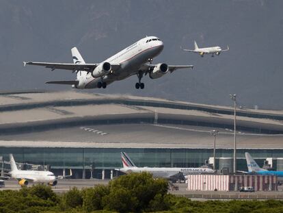 Un avión despega mientras otro aterriza en el aeropuerto, en una fotografía de archivo.
