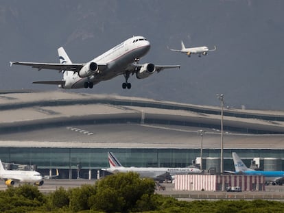 Un avión despega mientras otro aterriza simultáneamente en el aeropuerto de El Prat.