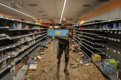 Los vecinos recogen productos de un supermercado afectado por las inundaciones, este jueves en Paiporta, Valencia.