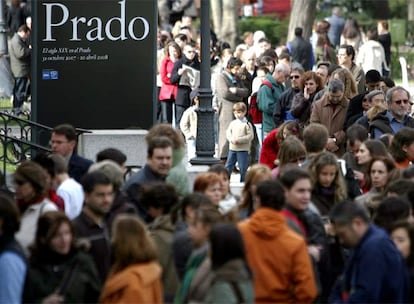 Una larga fila de personas aguarda pacientemente ante la entrada del Museo del Prado para ver una exposición.