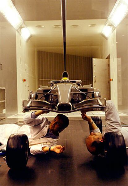 Dos mecánicos trabajan en el prototipo del 50% del coche real que se encuentra ubicado en el túnel de viento de Enstone, en Inglaterra.