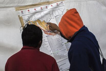 Dos inmigrantes observan un mapa de México, el objetivo de la caravana es llegar a la ciudad de Tijuana en el norte del país.