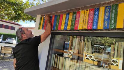 Un vecino escribe el nombre de distintos autores en la bibliocaseta restaurada de Ciudad Rodrigo.