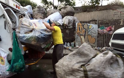 Un trabajador de limpia colecta basura en la Ciudad de M&eacute;xico.