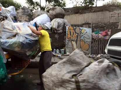 Un trabajador de limpia colecta basura en la Ciudad de M&eacute;xico.