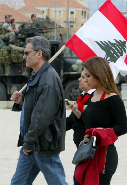 En la imagen, una familia libanesa pasea en Beirut ante una patrulla militar.