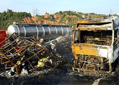 Los bomberos sofocan el fuego en uno de los cinco camiones implicados en un choque en Castellbisbal.