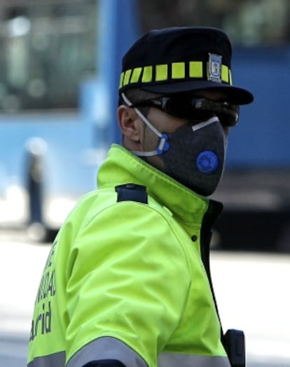 Un agente regulaba el tráfico ayer protegido con una mascarilla en el paseo de las Acacias de Madrid.