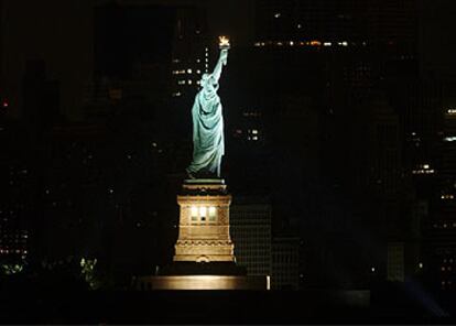 La estatua de la Libertad, iluminada en la oscuridad en la que ha quedado sumida la mayor parte de la ciudad.