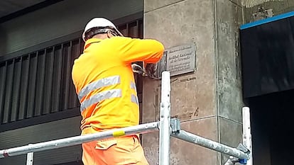 Un operario retira una placa franquista de un edificio de la calle de C&ograve;rsega.