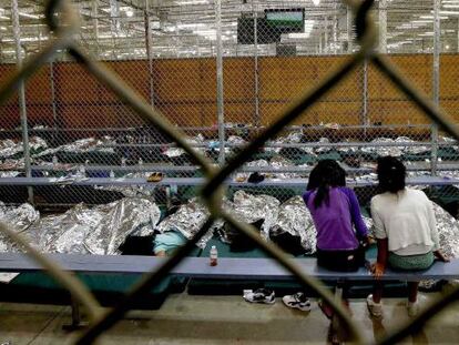 Dos niñas siguen un partido del Mundial desde uno de los recintos donde se está procesando a cientos de menores inmigrantes de Centroamérica.